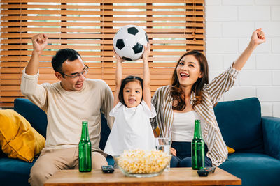 Portrait of smiling friends using digital tablet while sitting on table