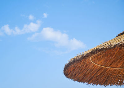 Low angle view of parasol against blue sky