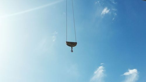 Low angle view of crane part against sky