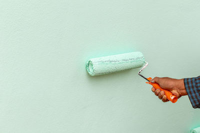 Hand holding paper against wall