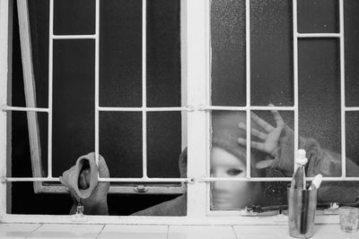 Close-up of burglar wearing mask peeking through window