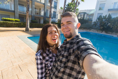 Portrait of happy young couple in swimming pool
