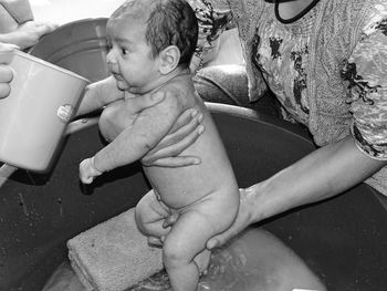 Midsection of mother bathing baby boy