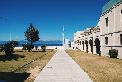 Walkway against clear blue sky