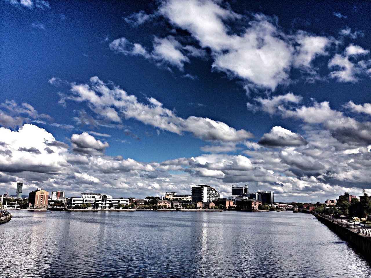 building exterior, architecture, built structure, city, water, waterfront, sky, cityscape, cloud - sky, skyscraper, river, urban skyline, cloud, modern, office building, cloudy, skyline, sea, residential district, tall - high