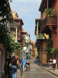 Rear view of people walking on houses in city