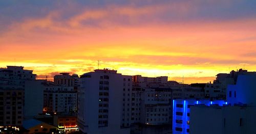 Buildings against dramatic sky during sunset