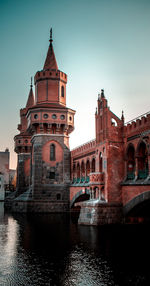 Bridge over river amidst buildings against sky