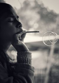 Close-up of woman blowing bubbles