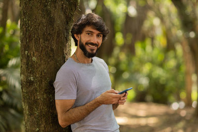 Young man at park on a beautiful sunny day with mobile phone.  working  leisure. green and nature 