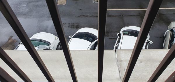 High angle view of cars parked on street seen through window