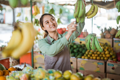 Portrait of woman holding fruits at market