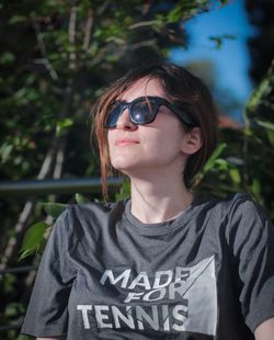 Close-up of woman wearing sunglasses while sitting outdoors