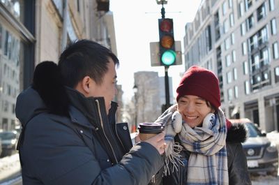 Portrait of young couple in city during winter