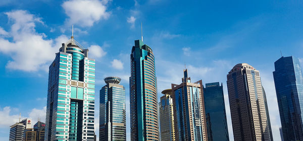 Low angle view of buildings against cloudy sky