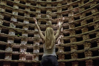 Rear view of woman standing in corridor of building