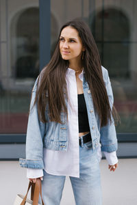 Portrait of young woman standing in city
