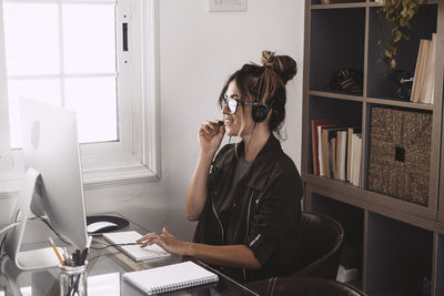 Smiling woman talking on video call at office