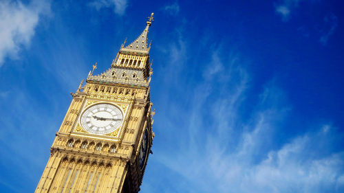 Low angle view of clock tower against cloudy sky