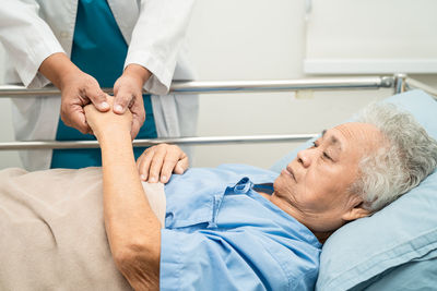 Midsection of senior man sleeping on bed at home