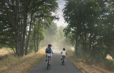 Two children on bicycles on a cycle path in burgundy