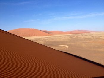 Scenic view of desert against blue sky