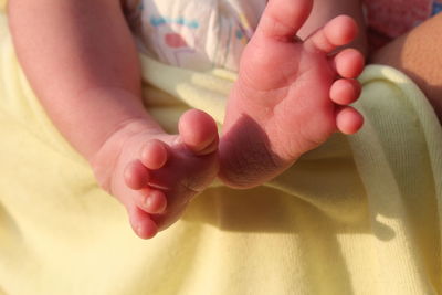 Low section of newborn lying on bed