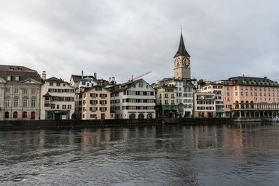 Buildings in city against cloudy sky