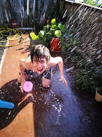 Water splashing on shirtless boy