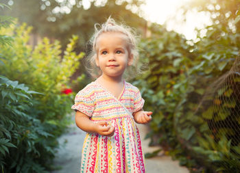 Portrait of cute girl standing against plants