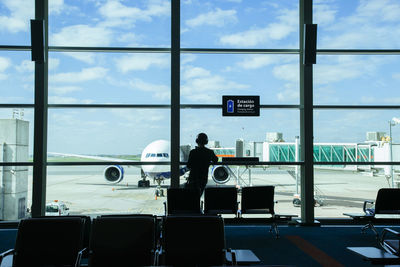 Rear view of man standing in waiting room at airport