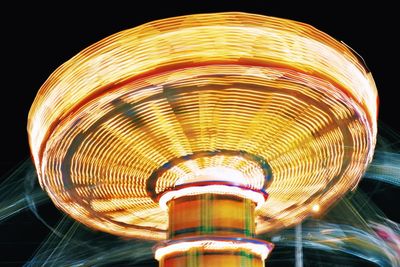 Low angle view of illuminated ferris wheel against sky at night