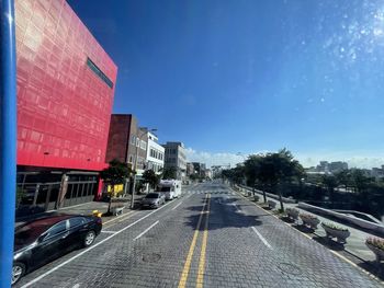 Road amidst buildings against sky in city