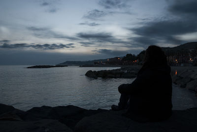 Rear view of woman sitting on beach