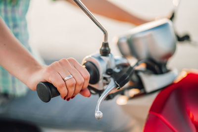 Cropped image of woman riding motor scooter