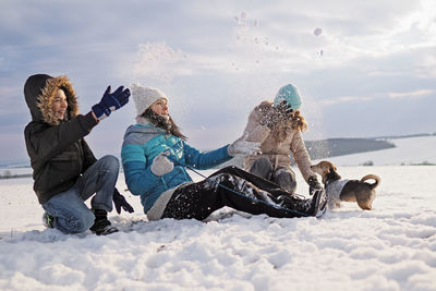 People sitting on snow covered land