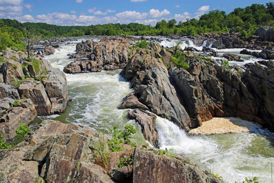 Scenic view of waterfall against sky