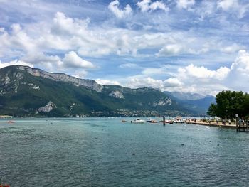 Scenic view of sea by mountains against sky