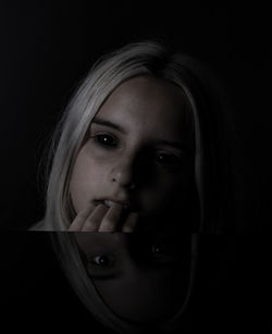 Close-up portrait of a girl over black background