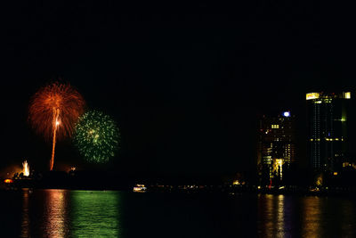 Firework display over river at night