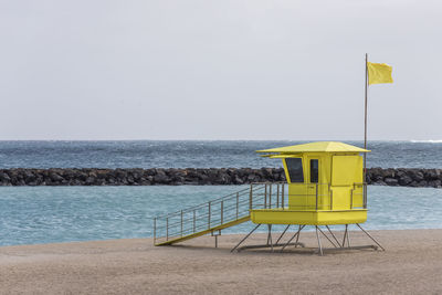Lifeguard hut on beach against clear sky