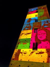 Low angle view of graffiti on wall at night