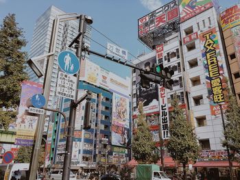 Low angle view of road sign against sky in city