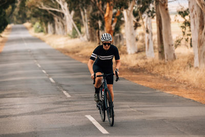 Female cyclist cycling on road