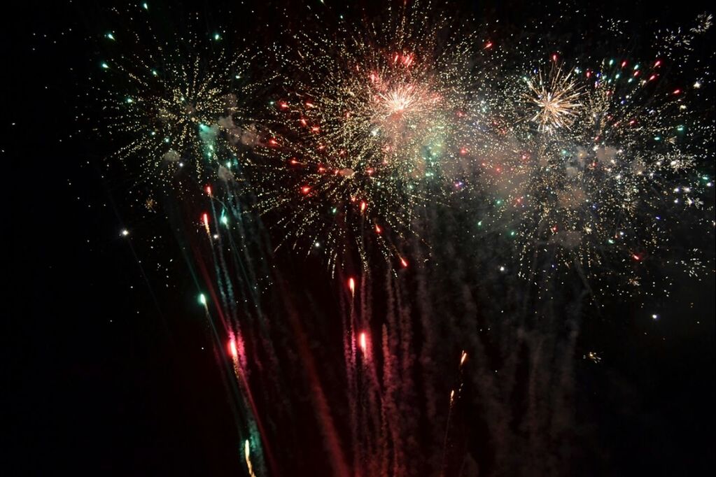 night, illuminated, firework display, celebration, long exposure, exploding, firework - man made object, motion, event, firework, glowing, arts culture and entertainment, blurred motion, sparks, entertainment, multi colored, low angle view, sky, celebration event, outdoors