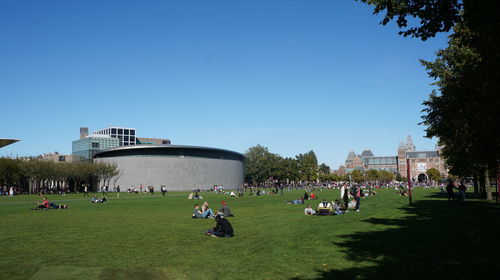 Group of people on built structure against clear blue sky