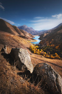 Landscape of beauty autumn day in mountain lake with stones at the front. vertical view of rocks