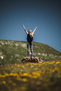 Hiker woman standing with hands up achieving the top. succesuful hike in the mountains
