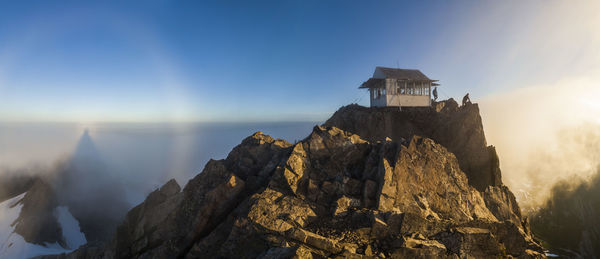 Hikers stand at sunrise outside three fingers lookout, north cascades