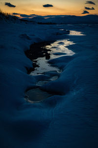 Frozen sea against sky during winter